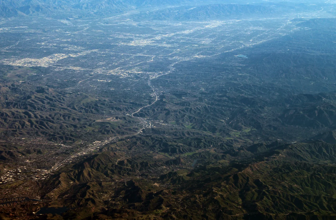 Aerial view of Calabasas and the San Fernando Valley, facing northeast from a passing jetliner off the coast of Oxnard (which had just departed from John Wayne Airport). This image has been balanced to compensate for haze and smog.
Photographed by user Coolcaesar on February 2, 2020.
