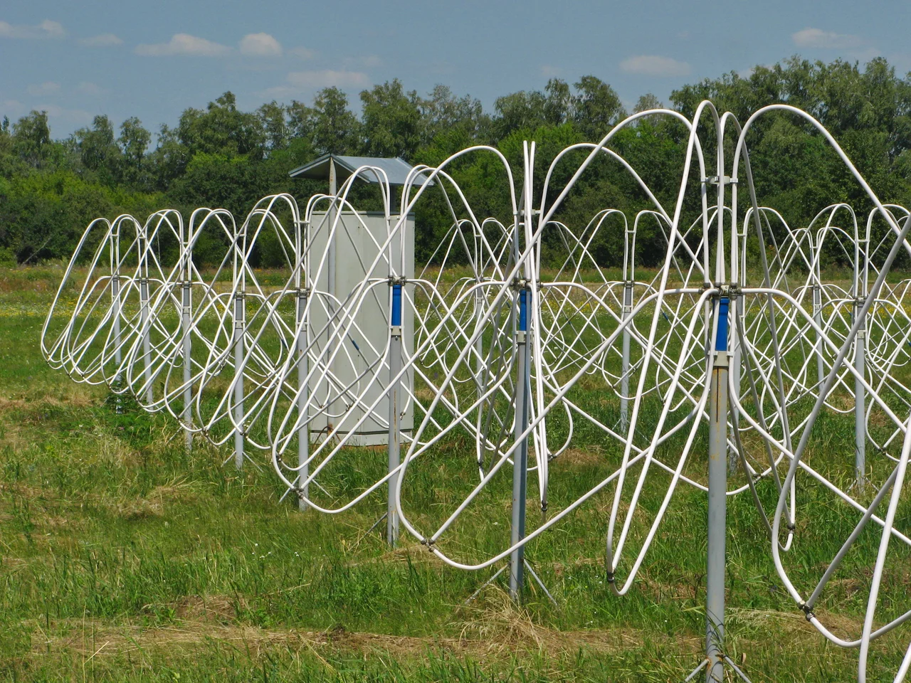 Some of the active dipole antennas of the Giant Ukrainian Radio Telescope (GURT) operated by the Institute of Radio Astronomy of the National Academy of Sciences of Ukraine, located in the Kharkiv region, Ukraine. It is a phased array radio telescope which receives radio waves in the range 8-80 MНz emitted by aatronomical objects in the sky. The basic antenna unit, shown here, is a 5x5 array of 25 crossed dipole antenna elements mounted 1.6 m above the ground, with a separation of 3.75 m. Many of these subarrays are scattered over the landscape.